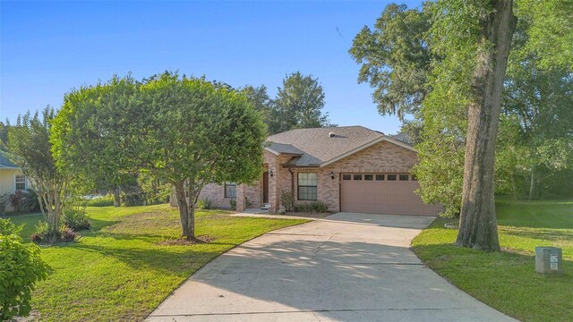 1120 W Glen Falls Rd, Deland, FL 32720 - view of front of property featuring concrete driveway, an attached garage, brick siding, and a front yard