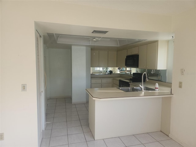 8 Oxford Ln, Palm Coast, FL 32137 - kitchen with black appliances, a peninsula, a sink, light tile patterned floors, and light countertops