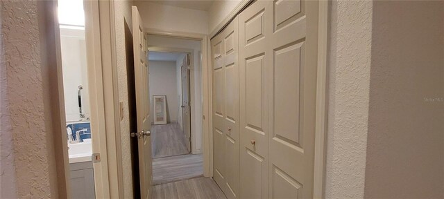 1621 Anniston Ave, Daytona Beach, FL 32117 - hall featuring a textured wall, light wood-type flooring, and a sink