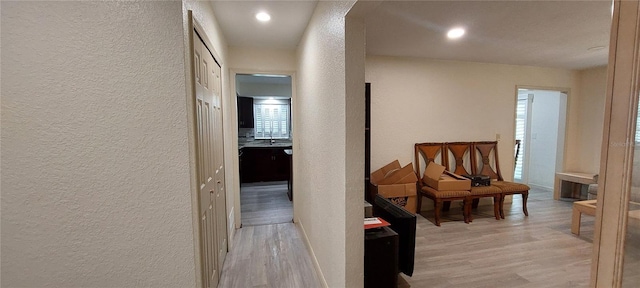 1621 Anniston Ave, Daytona Beach, FL 32117 - corridor with a textured wall, light wood-style flooring, a sink, and recessed lighting