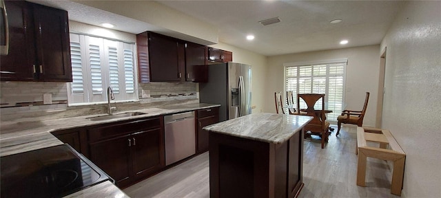 1621 Anniston Ave, Daytona Beach, FL 32117 - kitchen featuring stainless steel appliances, backsplash, a sink, a center island, and light wood-type flooring