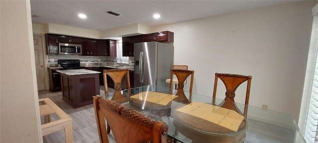 1621 Anniston Ave, Daytona Beach, FL 32117 - kitchen featuring appliances with stainless steel finishes, a kitchen island, light wood-style floors, tasteful backsplash, and recessed lighting