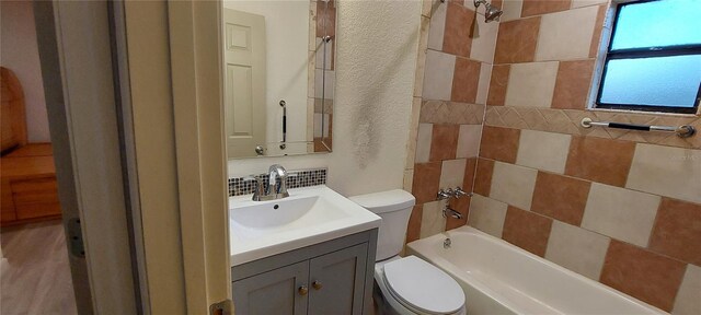 1621 Anniston Ave, Daytona Beach, FL 32117 - bathroom featuring toilet, vanity, shower / washtub combination, a textured wall, and decorative backsplash