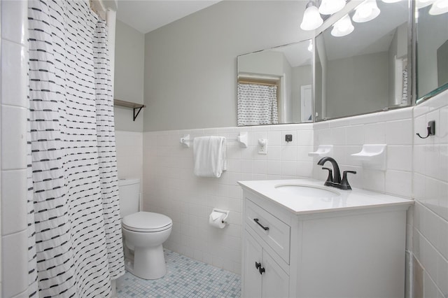 2842 English Dr, Deltona, FL 32738 - full bathroom with tile walls, toilet, tile patterned floors, vanity, and wainscoting