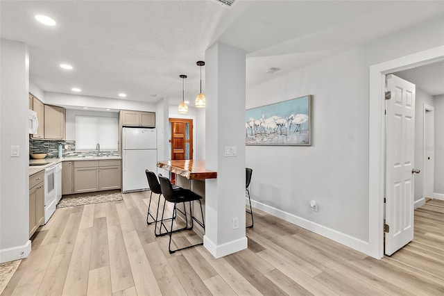 809 E 14th Ave, New Smyrna Beach, FL 32169 - kitchen with white appliances, light wood finished floors, a sink, baseboards, and decorative backsplash