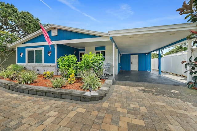 809 E 14th Ave, New Smyrna Beach, FL 32169 - view of front of home featuring decorative driveway, brick siding, and an attached carport