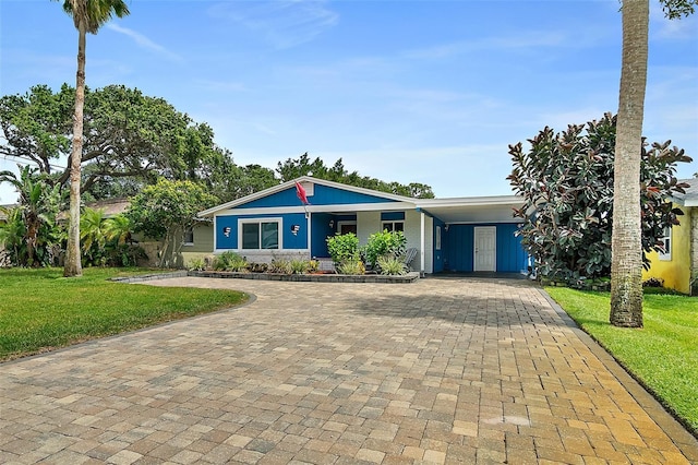 809 E 14th Ave, New Smyrna Beach, FL 32169 - single story home with decorative driveway, a front lawn, and a carport