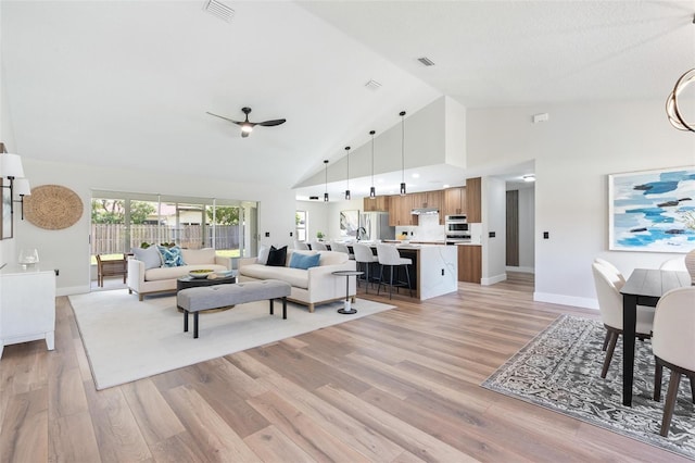23 Forest Hill Dr, Palm Coast, FL 32137 - living room featuring ceiling fan, baseboards, high vaulted ceiling, and light wood-type flooring