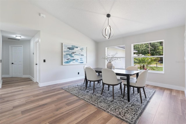23 Forest Hill Dr, Palm Coast, FL 32137 - dining space featuring light wood finished floors, baseboards, and vaulted ceiling
