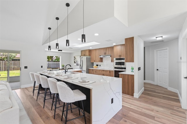23 Forest Hill Dr, Palm Coast, FL 32137 - kitchen featuring appliances with stainless steel finishes, brown cabinetry, a sink, under cabinet range hood, and recessed lighting