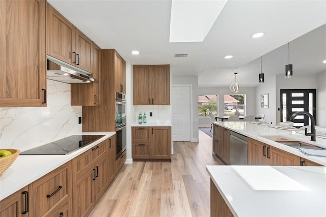 23 Forest Hill Dr, Palm Coast, FL 32137 - kitchen featuring stainless steel appliances, under cabinet range hood, a sink, brown cabinetry, and recessed lighting