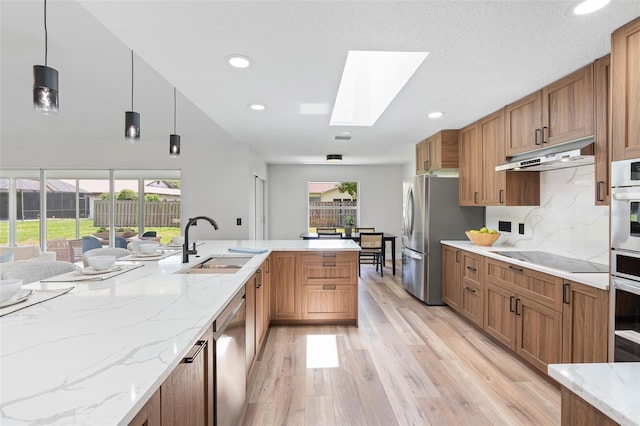 23 Forest Hill Dr, Palm Coast, FL 32137 - kitchen featuring a sink, appliances with stainless steel finishes, under cabinet range hood, a skylight, and light wood-style flooring