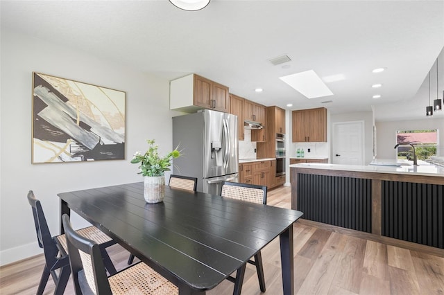23 Forest Hill Dr, Palm Coast, FL 32137 - dining room featuring a skylight, light wood-type flooring, recessed lighting, and baseboards