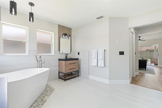 23 Forest Hill Dr, Palm Coast, FL 32137 - full bathroom featuring a freestanding bath, vanity, a ceiling fan, and baseboards