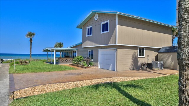 8 Ocean Dunes Dr, Ormond Beach, FL 32176 - rear view of house with a lawn, a water view, central AC, and a garage