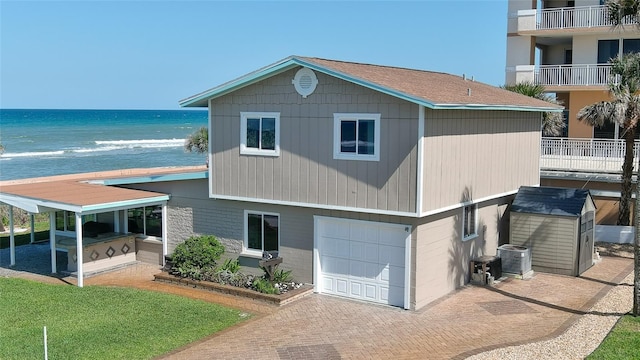 8 Ocean Dunes Dr, Ormond Beach, FL 32176 - view of front of property with a garage, a water view, central air condition unit, and decorative driveway