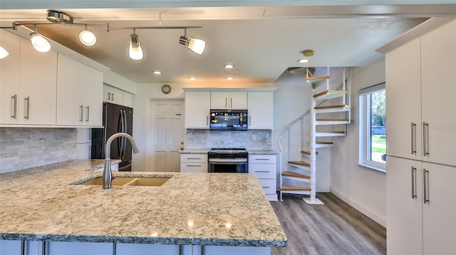 8 Ocean Dunes Dr, Ormond Beach, FL 32176 - kitchen featuring black appliances, tasteful backsplash, a peninsula, light wood-style flooring, and a sink