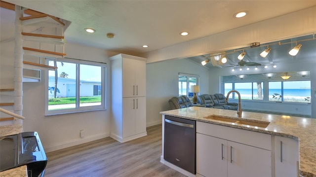8 Ocean Dunes Dr, Ormond Beach, FL 32176 - kitchen with stainless steel dishwasher, a sink, vaulted ceiling, light wood-style floors, and white cabinetry