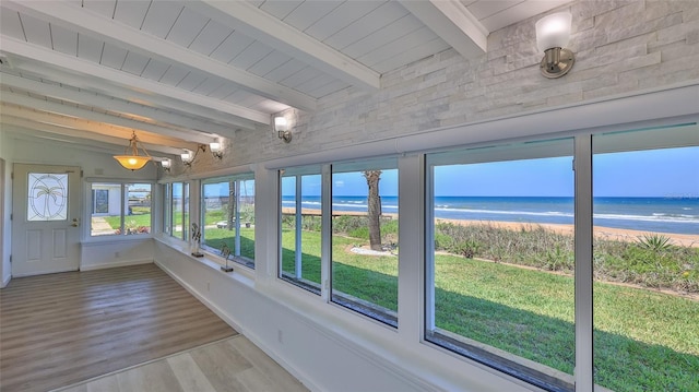 8 Ocean Dunes Dr, Ormond Beach, FL 32176 - unfurnished sunroom with view of water and beach, wood finished floors, beam ceiling, and baseboards
