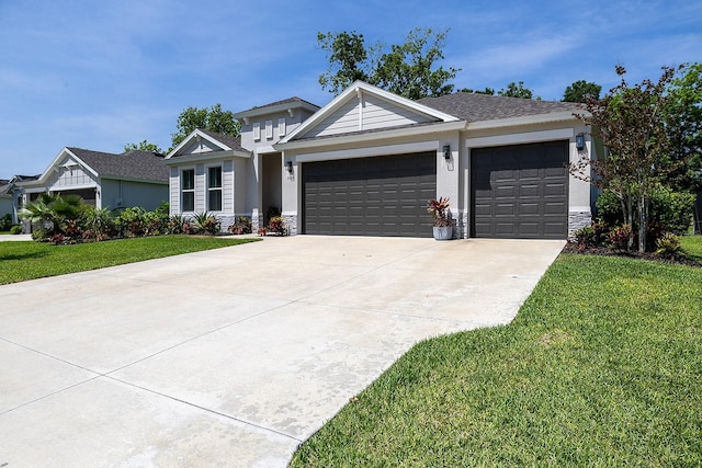 3026 Adrian Dr, Ormond Beach, FL 32174 - view of front of property featuring an attached garage, a front lawn, concrete driveway, and stone siding