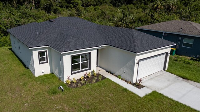 248 S Virginia Ave, Deland, FL 32724 - view of front of home with roof with shingles, a garage, driveway, stucco siding, and a front lawn