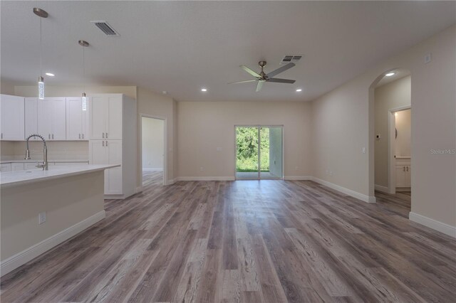 248 S Virginia Ave, Deland, FL 32724 - unfurnished living room featuring a sink, a ceiling fan, wood finished floors, arched walkways, and recessed lighting