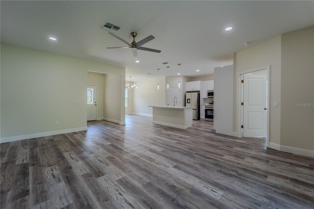 248 S Virginia Ave, Deland, FL 32724 - unfurnished living room featuring ceiling fan, wood finished floors, recessed lighting, a sink, and a chandelier