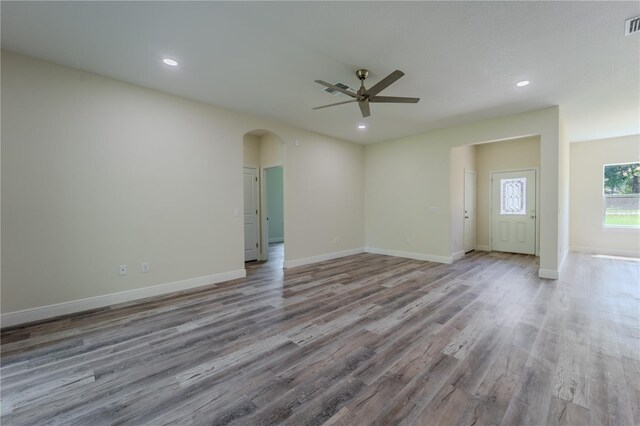 248 S Virginia Ave, Deland, FL 32724 - unfurnished living room featuring a ceiling fan, arched walkways, wood finished floors, baseboards, and recessed lighting