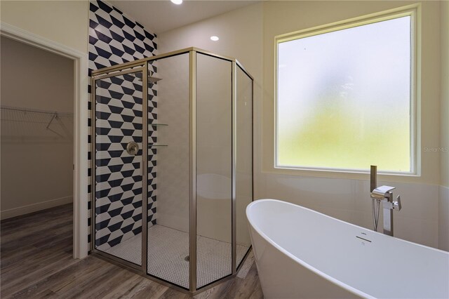 248 S Virginia Ave, Deland, FL 32724 - bathroom featuring a stall shower, a freestanding tub, wood finished floors, and healthy amount of natural light