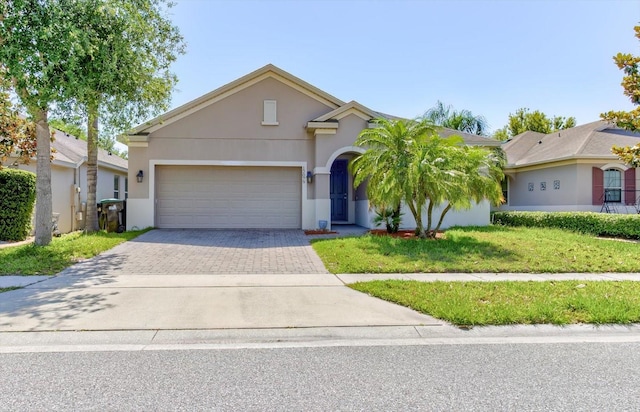 12079 Alder Branch Loop, Orlando, FL 32824 - view of front of property featuring driveway, stucco siding, an attached garage, and a front lawn