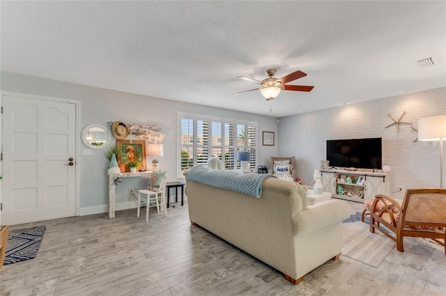 114 Ocean Aire Ter N, Ormond Beach, FL 32176 - living room featuring a ceiling fan, light wood-style floors, brick wall, and baseboards