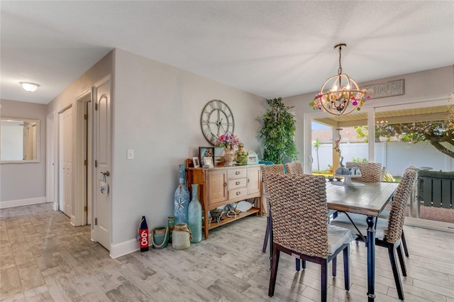 114 Ocean Aire Ter N, Ormond Beach, FL 32176 - dining area with a chandelier, light wood-style flooring, and baseboards
