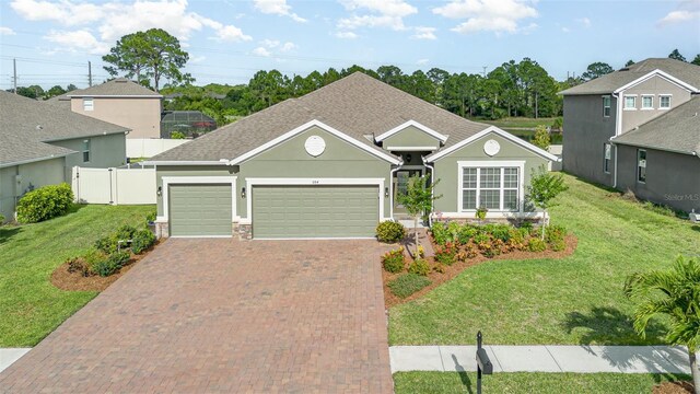 684 Stonebriar Dr SE, Palm Bay, FL 32909 - traditional-style house featuring an attached garage, decorative driveway, stucco siding, and a shingled roof