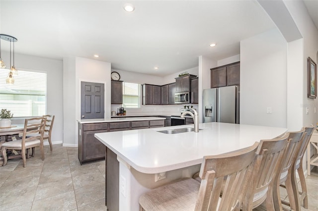 684 Stonebriar Dr SE, Palm Bay, FL 32909 - kitchen featuring stainless steel appliances, a sink, light countertops, dark brown cabinetry, and baseboards