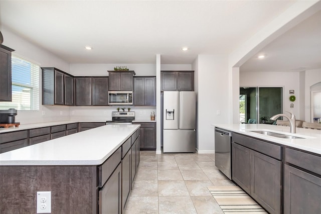 684 Stonebriar Dr SE, Palm Bay, FL 32909 - kitchen featuring appliances with stainless steel finishes, a sink, arched walkways, dark brown cabinetry, and light countertops