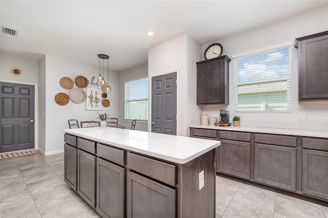684 Stonebriar Dr SE, Palm Bay, FL 32909 - kitchen with light countertops, a kitchen island, healthy amount of natural light, dark brown cabinetry, and recessed lighting