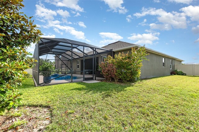 684 Stonebriar Dr SE, Palm Bay, FL 32909 - rear view of house featuring stucco siding, glass enclosure, and a patio