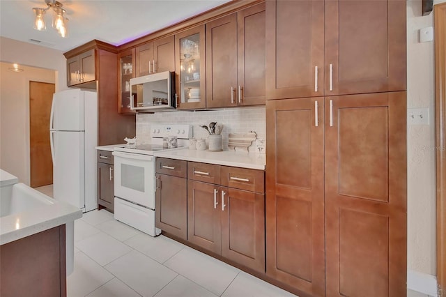 953 Tulip St, Deltona, FL 32725 - kitchen featuring white appliances, backsplash, light tile patterned flooring, glass insert cabinets, and brown cabinets