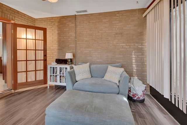 953 Tulip St, Deltona, FL 32725 - sitting room featuring brick wall and wood finished floors