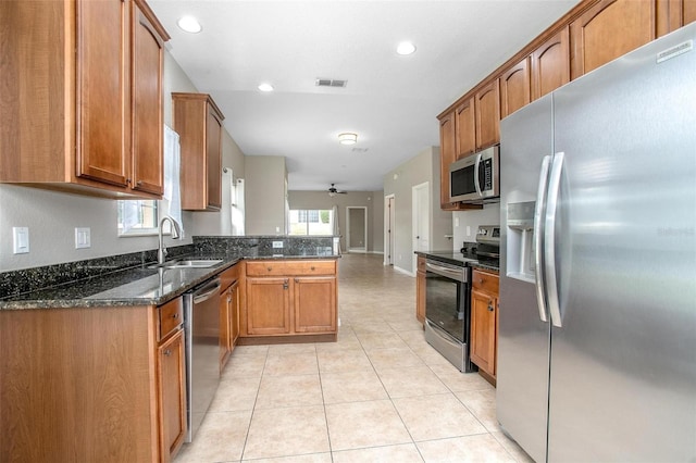 201 Dyson Dr, Deland, FL 32724 - kitchen featuring stainless steel appliances, brown cabinetry, a peninsula, plenty of natural light, and recessed lighting
