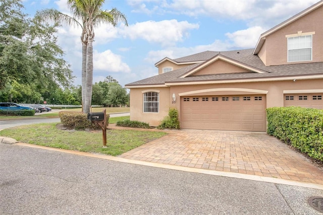 201 Dyson Dr, Deland, FL 32724 - view of front facade featuring stucco siding, decorative driveway, and roof with shingles
