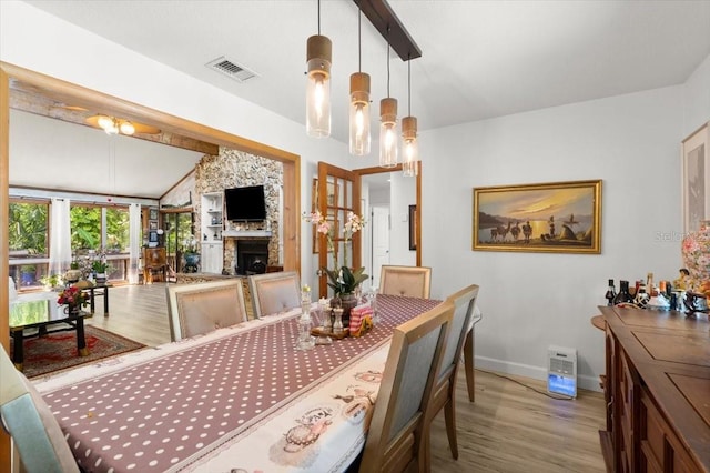 96 Hollow Branch Xing, Ormond Beach, FL 32174 - dining space with light wood-style floors, lofted ceiling, a fireplace, baseboards, and a chandelier