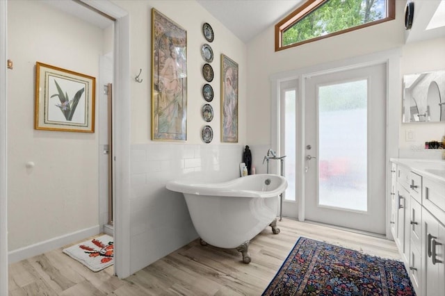 96 Hollow Branch Xing, Ormond Beach, FL 32174 - full bathroom with wood finished floors, vanity, a freestanding tub, lofted ceiling, and wainscoting