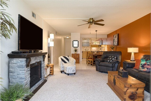 325 Wilder Blvd Unit A102, Daytona Beach, FL 32114 - tiled living room featuring a ceiling fan, carpet flooring, and a fireplace
