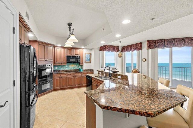 2901 S Atlantic Ave Unit 401, Daytona Beach Shores, FL 32118 - kitchen with black appliances, a sink, a breakfast bar, recessed lighting, and a water view
