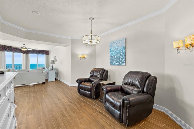 2901 S Atlantic Ave Unit 401, Daytona Beach Shores, FL 32118 - sitting room featuring a chandelier, light wood finished floors, baseboards, crown molding, and a water view
