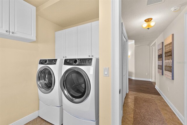 2901 S Atlantic Ave Unit 401, Daytona Beach Shores, FL 32118 - washroom with washing machine and clothes dryer, cabinet space, light tile patterned flooring, and baseboards