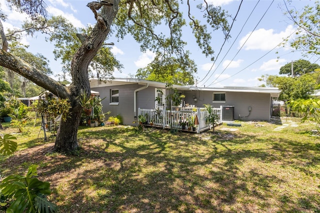 1284 Vanderbilt Dr, Ormond Beach, FL 32174 - back of property featuring a yard, a wooden deck, and central AC
