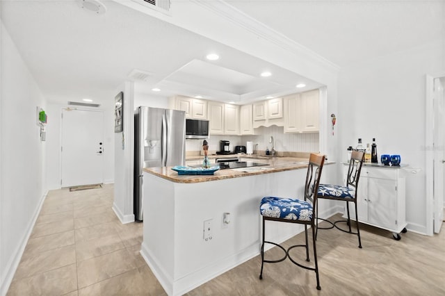 2987 S Atlantic Unit 606, Daytona Beach Shores, FL 32118 - kitchen with stainless steel appliances, a peninsula, recessed lighting, a kitchen breakfast bar, and ornamental molding