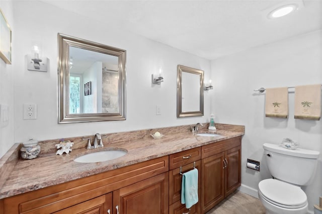 2987 S Atlantic Unit 606, Daytona Beach Shores, FL 32118 - bathroom featuring toilet, double vanity, and baseboards